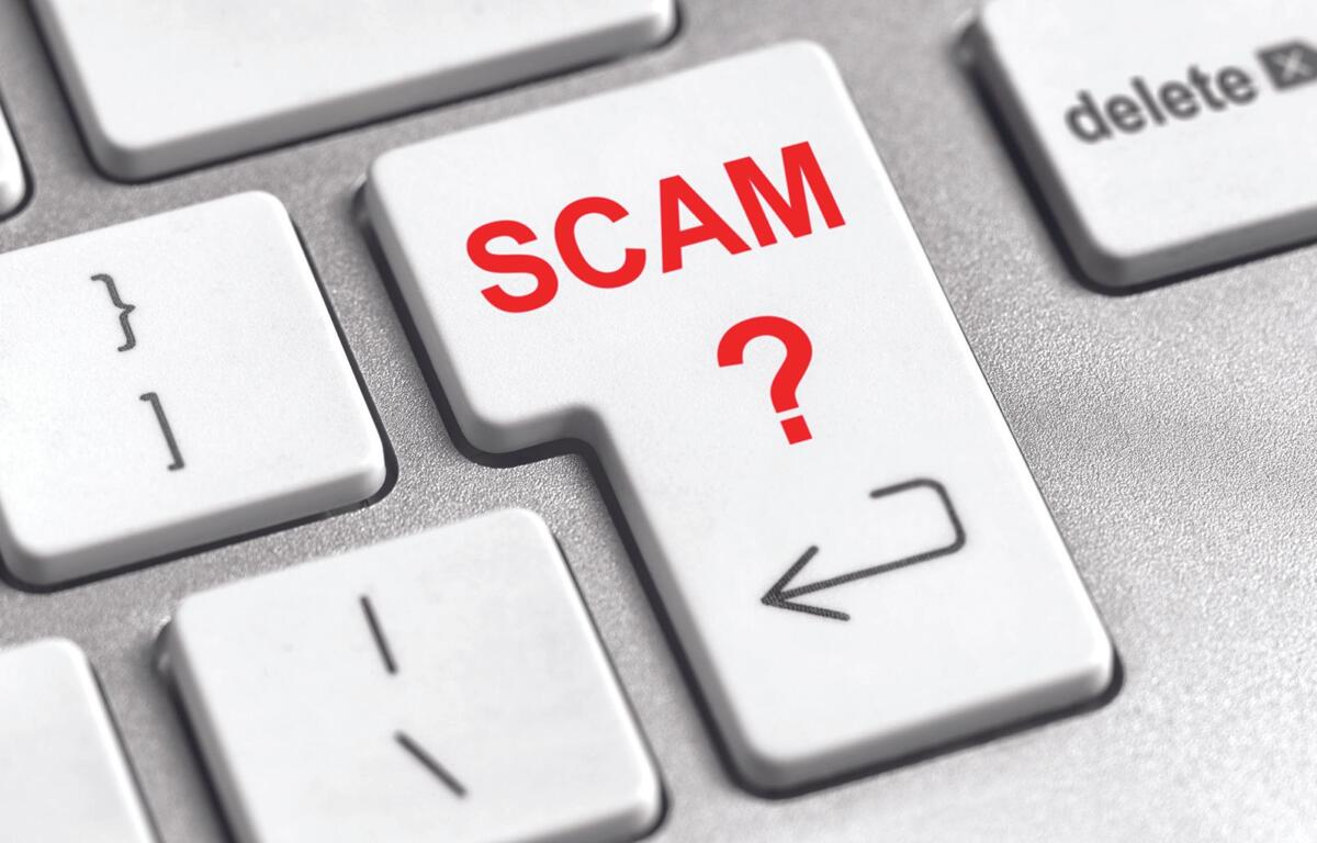 Key on a keyboard labeled SCAM with a red question mark, suggesting online scams or fraud awareness