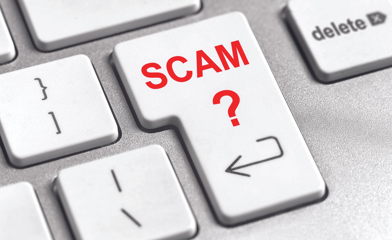 Key on a keyboard labeled SCAM with a red question mark, suggesting online scams or fraud awareness