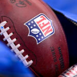 Close-up of a textured football featuring the NFL shield logo in focus