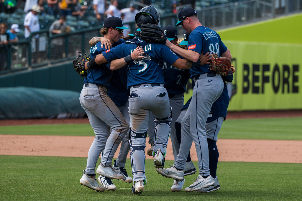 A group of baseball players in blue uniforms huddle together on the field in celebration.
