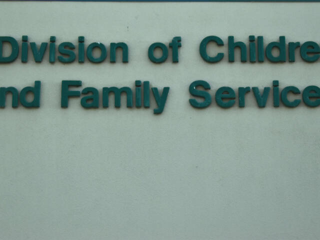 Teal raised lettering reading 'Division of Children and Family Services' on a pale wall.