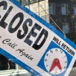 Storefront window displaying a large 'CLOSED' notice with 'Will return' text and a clock illustration showing return hours.