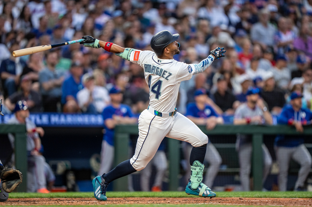 Baseball player Rodriguez, number 14, swings a bat during a game with a packed stadium crowd in the background.