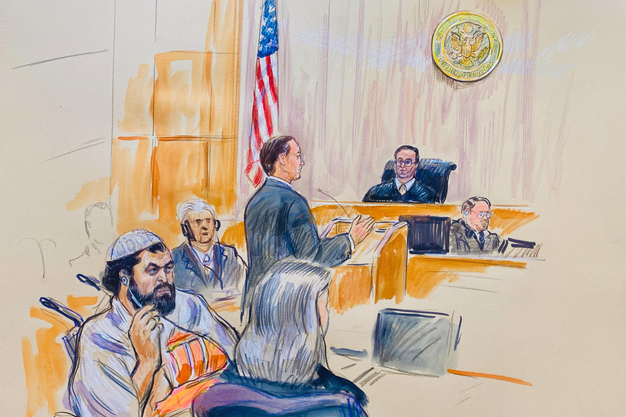 Courtroom scene with a judge at the bench, a lawyer speaking, and several attendees, an American flag in the background