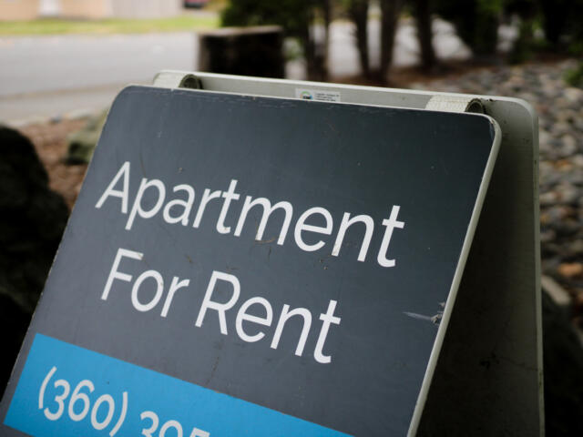 Signboard advertising an apartment for rent with a blue price strip in the foreground.