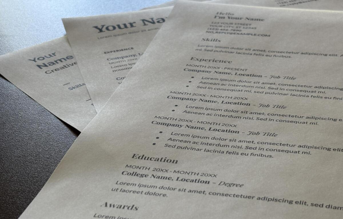 Close-up of multiple resume templates with placeholder text like 'Your Name' and 'Education' on a textured surface.