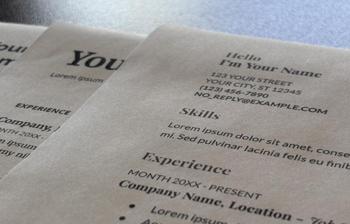 Close-up of printed sheets with placeholder text and headings like 'Hello I'm Your Name' on a light background temporary layout.