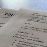 Close-up of printed sheets with placeholder text and headings like 'Hello I'm Your Name' on a light background temporary layout.