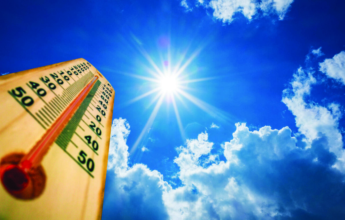 Thermometer in the lower-left foreground with a clear, radiant sun and blue sky, suggesting very hot weather (around 40–50°C).