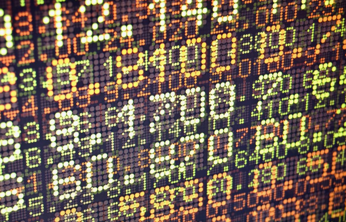 Close-up of a colorful LED dot matrix displaying stock ticker numbers and percentage changes.