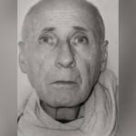 Black-and-white head-and-shoulders portrait of an elderly man with a light scarf around his neck.