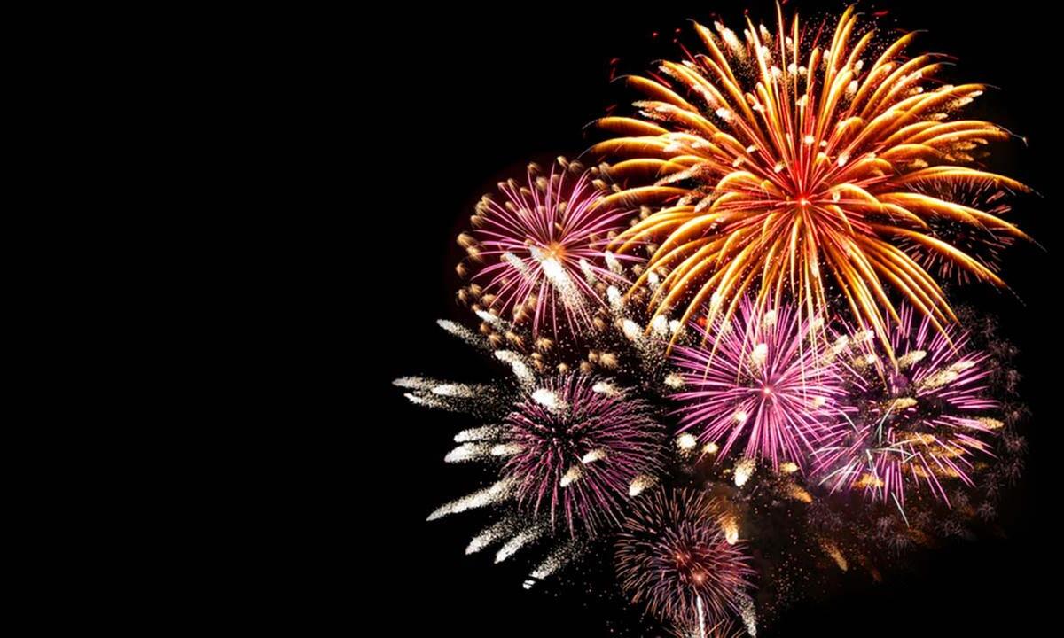 Colorful fireworks exploding in the night sky against a black background.