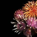Colorful fireworks exploding in the night sky against a black background.