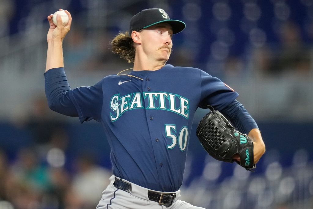 Right-handed pitcher from Seattle in a blue jersey winding up to throw a pitch (number 50).