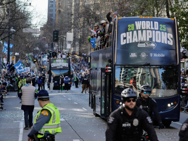 Blue double-decker parade bus with 'World Champions' sign, fans cheering on sidewalks and police in foreground.