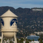 Water tower with Paramount logo in the foreground, hills and the Hollywood sign visible in the background.
