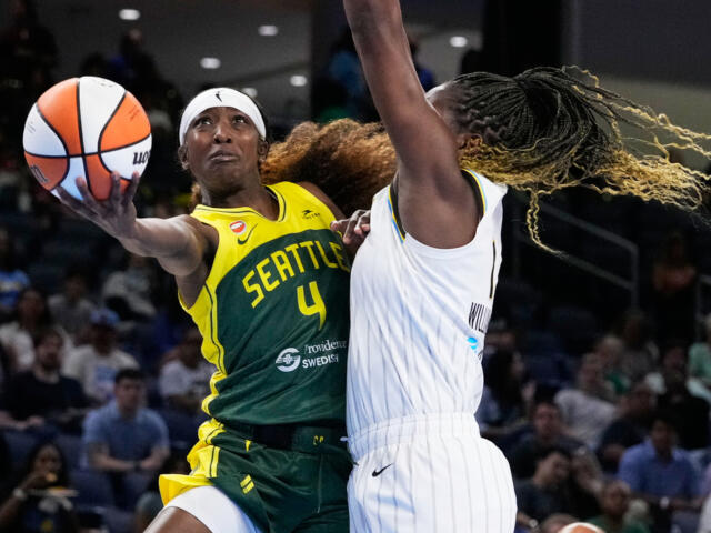Seattle Storm player (#4) in yellow-green uniform drives with the ball as a defender in white reaches in near the hoop area?