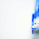 Close-up of a blue RJ-45 Ethernet connector with gold contacts at the right edge on a white background, taken from the side
