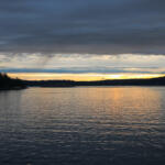 The Salish Sea with San Juan Islands in the west. Heavy storm clouds are overhead.