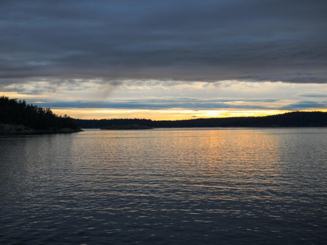 The Salish Sea with San Juan Islands in the west. Heavy storm clouds are overhead.