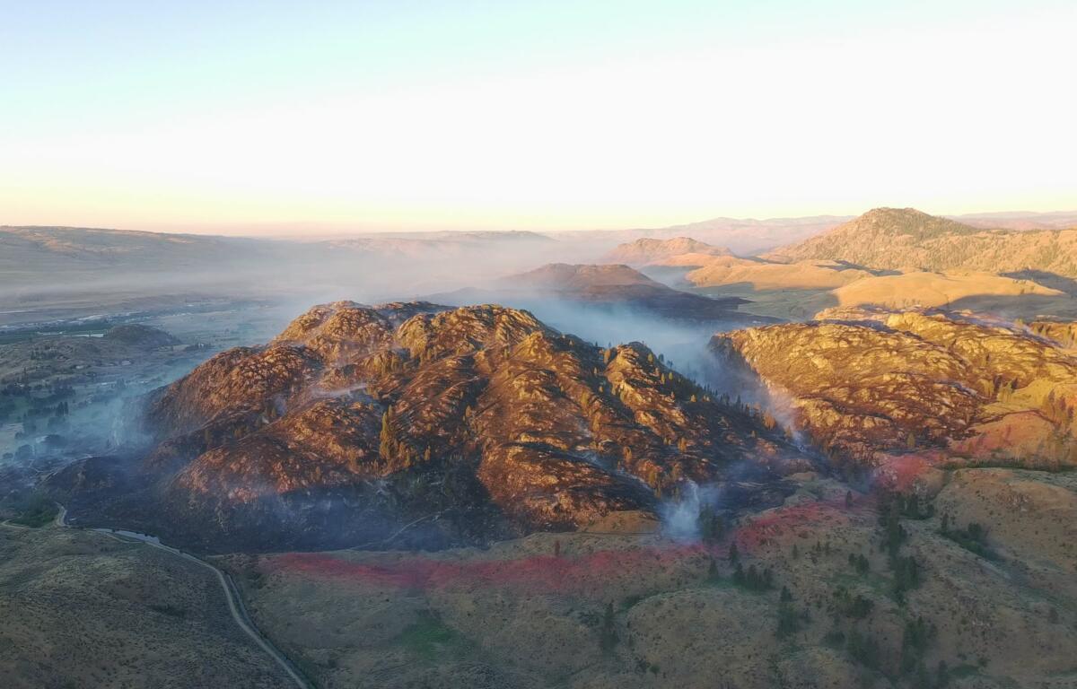 Mountain ridge at sunrise with soft fog filling the valleys and distant hills bathed in warm light