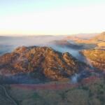 Mountain ridge at sunrise with soft fog filling the valleys and distant hills bathed in warm light